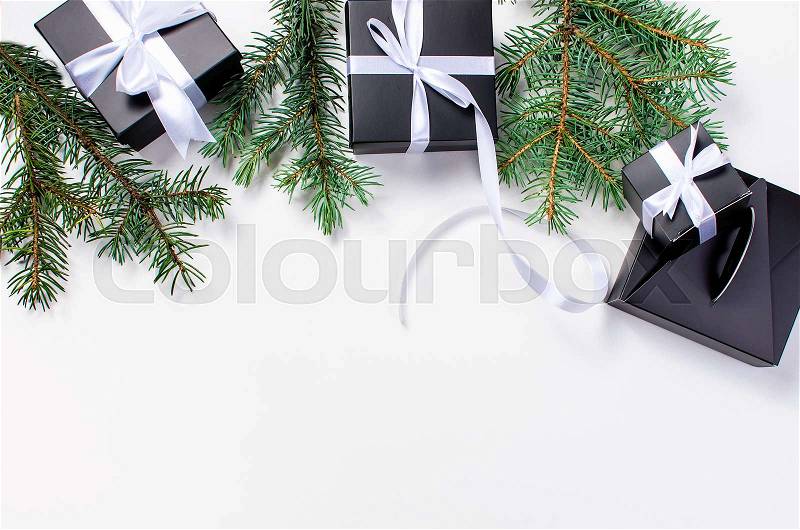 Black and white Christmas background. black gift box, balls, fir branches, silver Christmas decorations on the white background copy space, stock photo