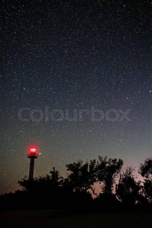Silhouette of the Lighthouse and trees against the background of the starry sky, stock photo