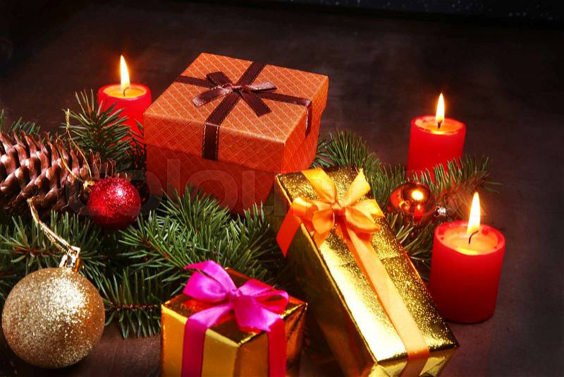 Christmas decoration with gift boxes, red candles, christmas tree and colorful balls. Selective focus, stock photo