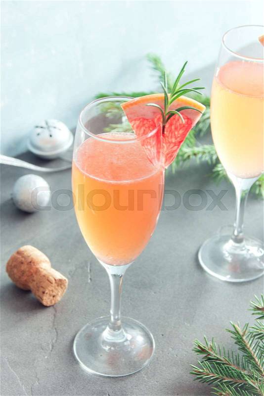 Mimosa festive drink for Christmas - Champagne cocktail Mimosa with Grapefruit and Rosemary for party, copy space, stock photo