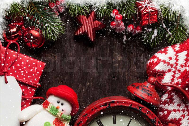 Christmas fir tree, decor, gift box and mittens over old wooden texture background. Top view with copy space for your greetings, stock photo