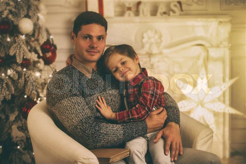 Father with son at home on Christmas evening, stock photo