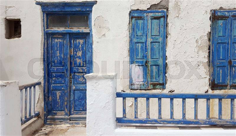 Old house with old blue door and windows in Greece, stock photo