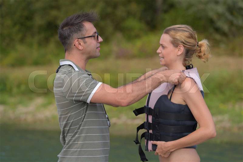 Coach putting the life vest properly, stock photo