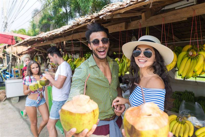 Couple Drink Coconut Cocktail On Street Traditional Fruits Market, Young Man And Woman Travelers, stock photo