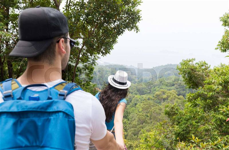 Couple With Backpacks Trekking In Forest Back Rear View, Young Man And Woman Holding Hands Walk On Hike Tourists Adventure Activity, stock photo
