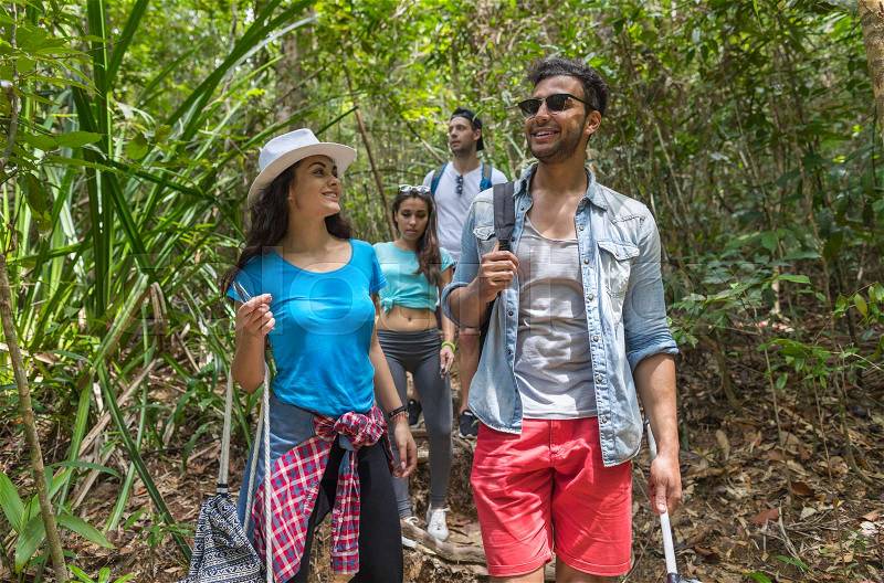 People Group With Backpacks Trekking On Forest Path, Mix Race Young Men And Woman On Hike Tourists Adventure Activity, stock photo