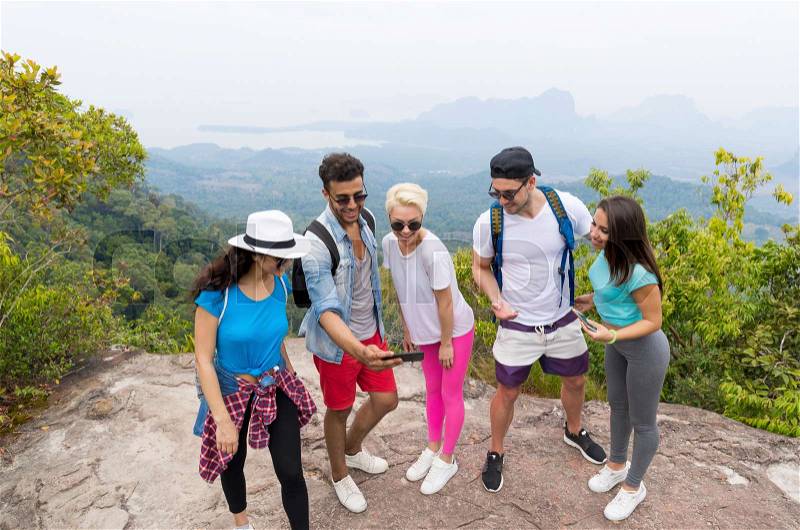 Tourist Group Watch Photos On Cell Smart Phones, People With Backpack Over Landscape From Mountain Top, Young Frineds On Hike, stock photo