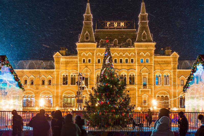 Beautiful Christmas tree on the background of GUM on Red Square in Moscow, Russia, evening shot in a snowstorm, stock photo