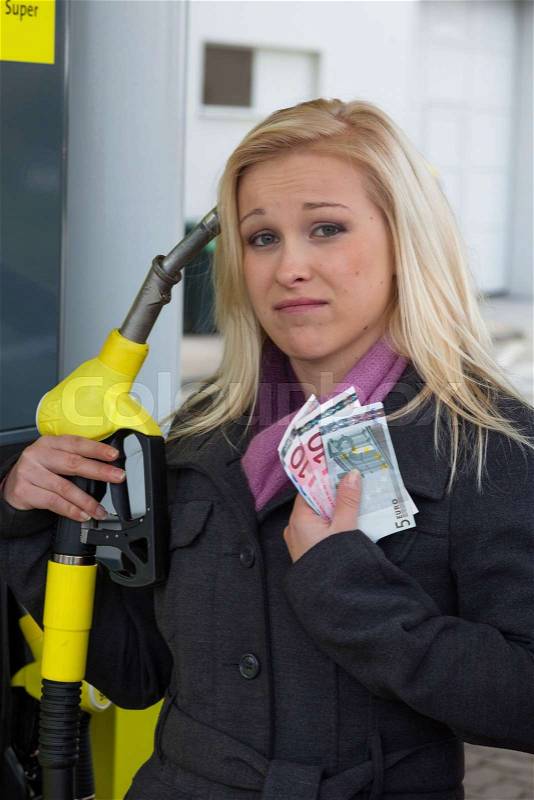 A young woman gasoline fuel on a gas station. the cost of the car is becoming more expensive because of gasoline prices, stock photo
