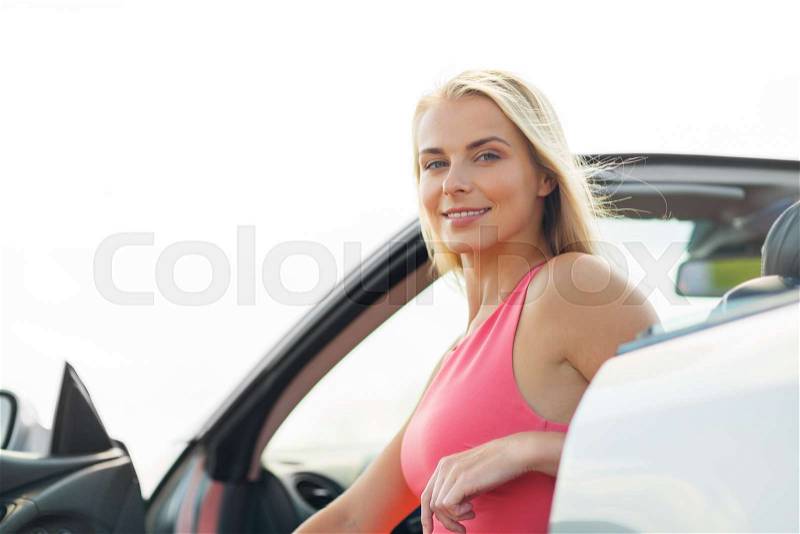 Travel, road trip and people concept - happy young woman in convertible car, stock photo