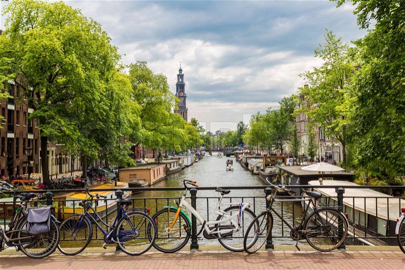 Bicycles on a bridge over the canals of Amsterdam, Netherlands in a summer day, stock photo