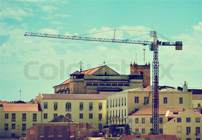 Industrial construction crane in old town, stock photo