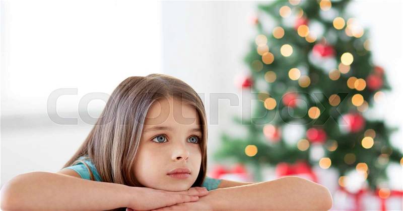Holidays, childhood, sadness and people concept - beautiful sad or bored girl at christmas, stock photo
