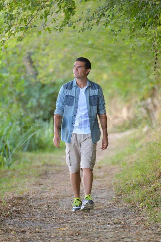 Man walking along path in the countryside, stock photo