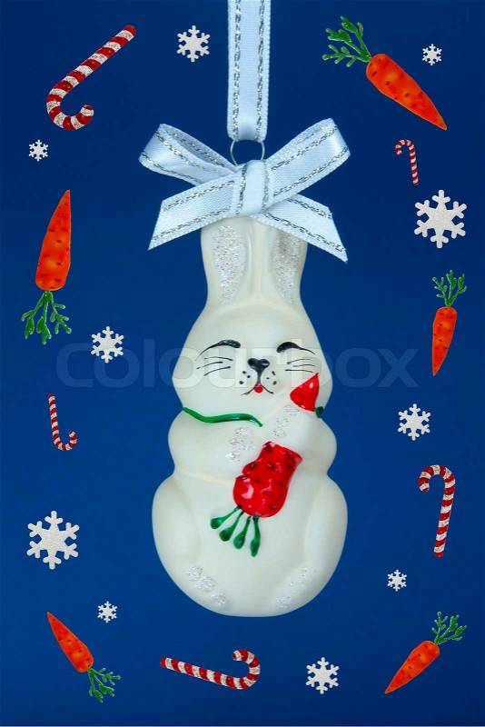 Fanny rabbit witn snowflakes, candy-canes and carrots Deep blue background, stock photo
