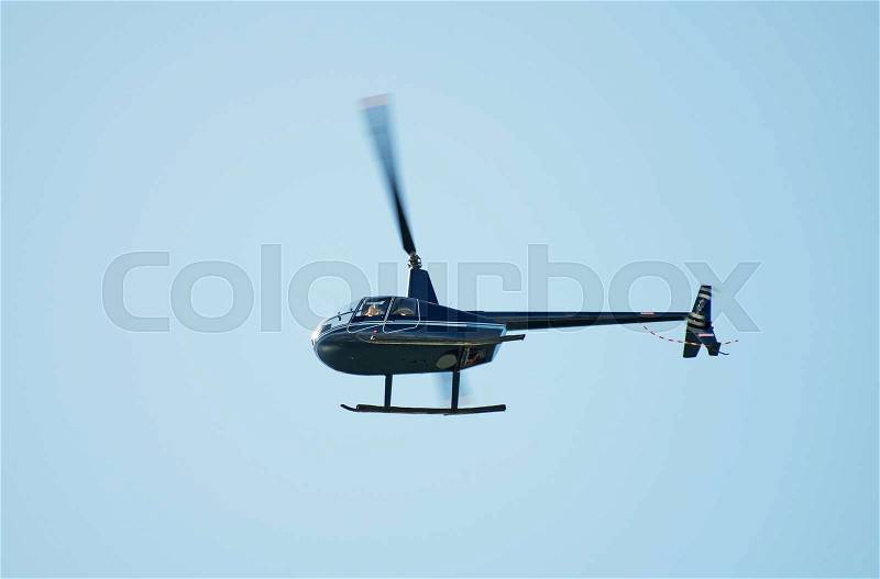 Small private helicopter in the sky, stock photo