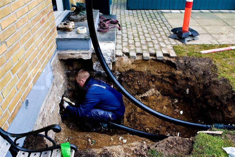 Works leads district heating pipes up to property, stock photo