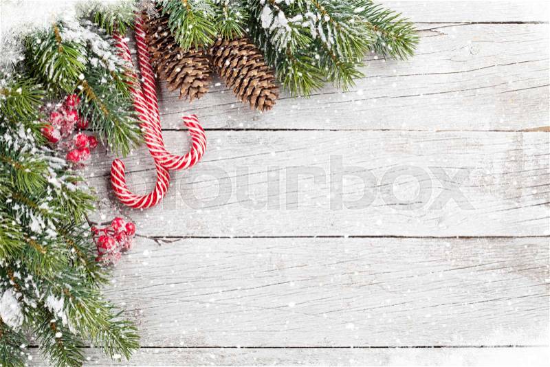 Christmas candy canes and snow fir tree on wooden table. Top view with space for your greetings, stock photo