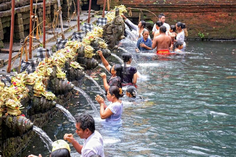 TAMPAK SIRING, BALI, INDONESIA - OCTOBER 30: People praying at holy spring water temple Puru Tirtha Empul during purification ceremony on October 30, 2011 in Tampak Siring, Bali, Indonesia, stock photo