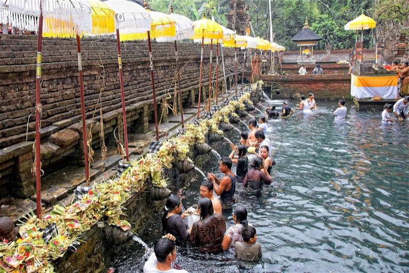 TAMPAK SIRING, BALI, INDONESIA - OCTOBER 30: People praying at holy spring water temple Puru Tirtha Empul during purification ceremony on October 30, 2011 in Tampak Siring, Bali, Indonesia, stock photo