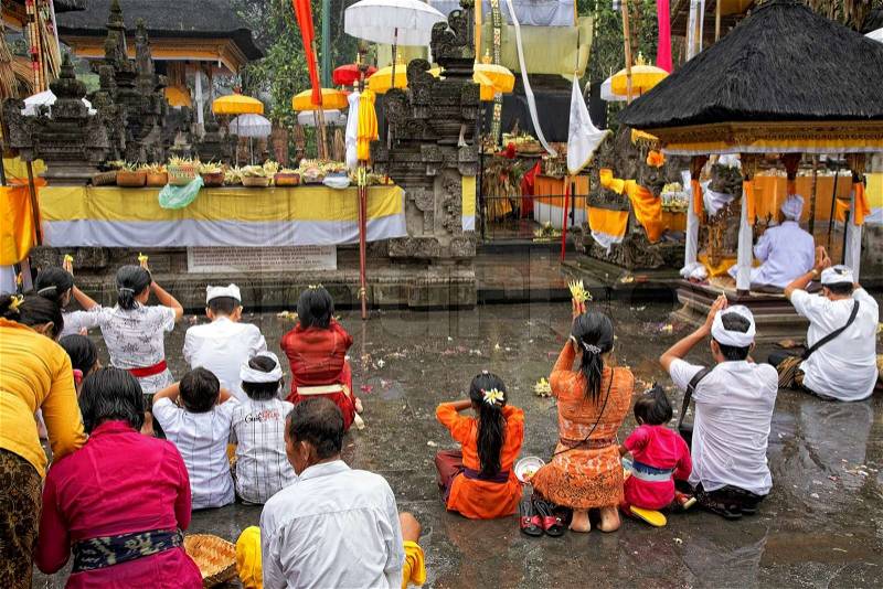 TAMPAK SIRING, BALI, INDONESIA - OCTOBER 30: People praying at holy spring water temple Puru Tirtha Empul during the religious ceremony on October 30, 2011 in Tampak Siring, Bali, Indonesia, stock photo