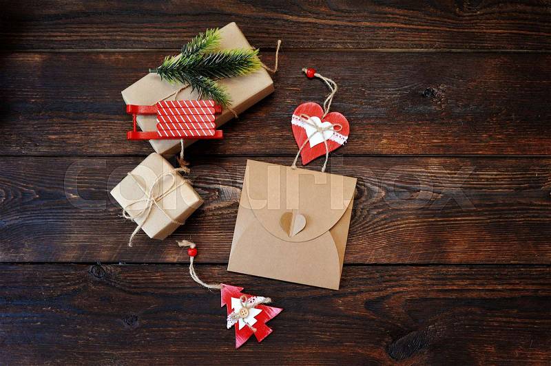Christmas Composition set of gift kraft boxes with a decor of a fir-tree, sleds and heart on wooden background. Flat lay, top view photo mockup, stock photo
