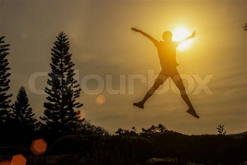 Silhouette of happy people jumping in sunset, stock photo