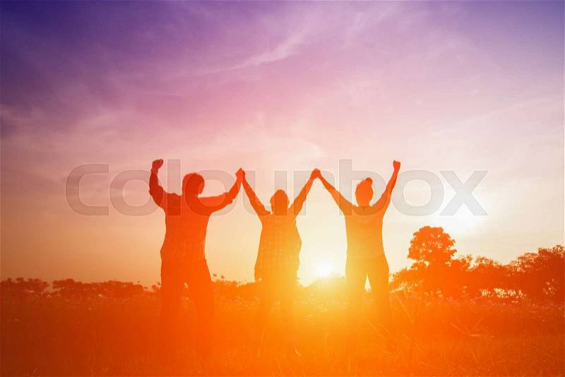 Silhouette image of happy family making high hands in sunset, stock photo