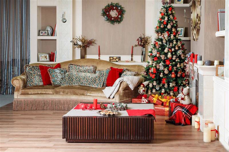 Cozyness and home comfort. Sofa near the decorated Christmas tree and fireplace with firewood. Winter holidays room interior, Christmas atmosphere, stock photo