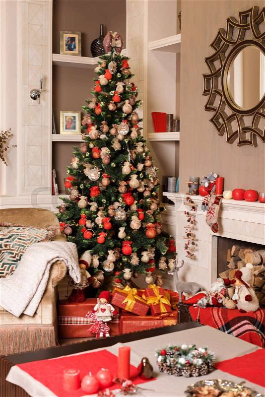 Cozyness and home comfort. Sofa near the decorated Christmas tree and fireplace with firewood. Winter holidays room interior, Christmas atmosphere, stock photo
