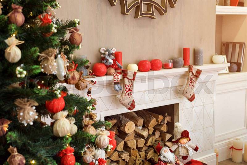 Cozyness and home comfort. Decorated Christmas tree and fireplace with firewood. Winter holidays room interior, Christmas atmosphere, stock photo