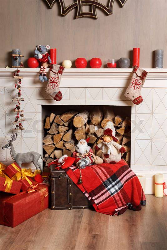 Cozyness and home comfort. Decorated fireplace with firewood. Winter holidays room interior, Christmas atmosphere, stock photo