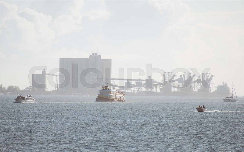 Many ships on Tagus river. Behind the port terminal with cranes, stock photo