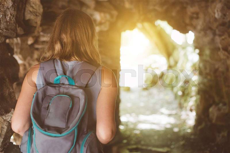 Woman with backpack in the cave, stock photo