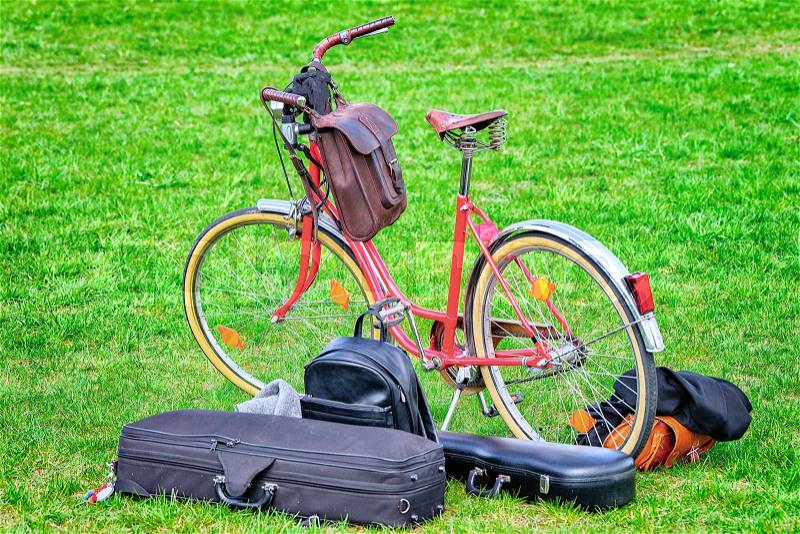 City bicycle and boxes for musical instruments on the green lawn, stock photo