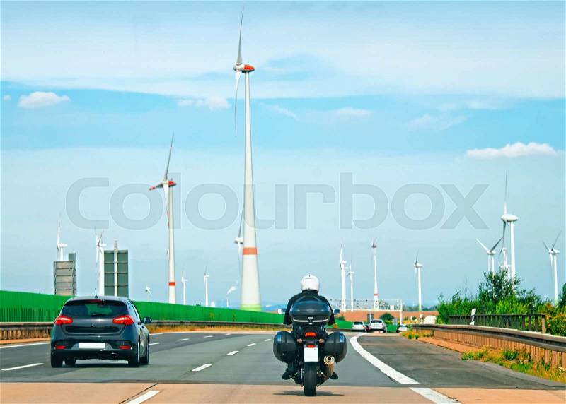 Wind mills and motorbike on the road in Switzerland, stock photo