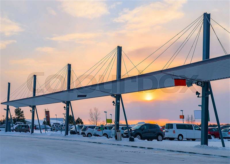 Cars in parking at Rovaniemi airport in winter at sunset, stock photo