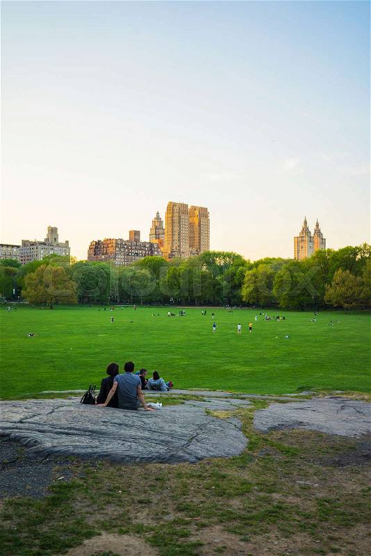 Couple looking at Uptown Manhattan skyline in Central Park West. On Upper West Side in New York, NYC, USA. People nearby, stock photo
