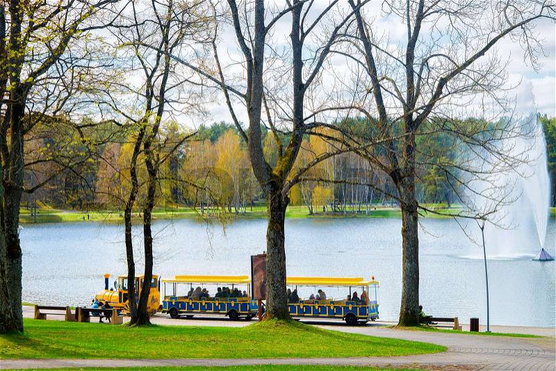 Excursion train with tourists, water fountain on Druskonis Lake and the nature in Druskininkai, Lithuania, stock photo