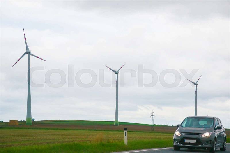 Wind mills and car on road in South Moravia, Czech Republic, stock photo