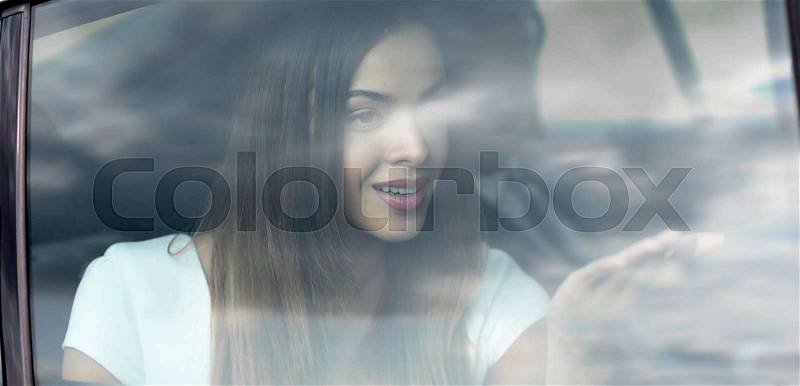 Young woman portrait in the car behind the window, stock photo