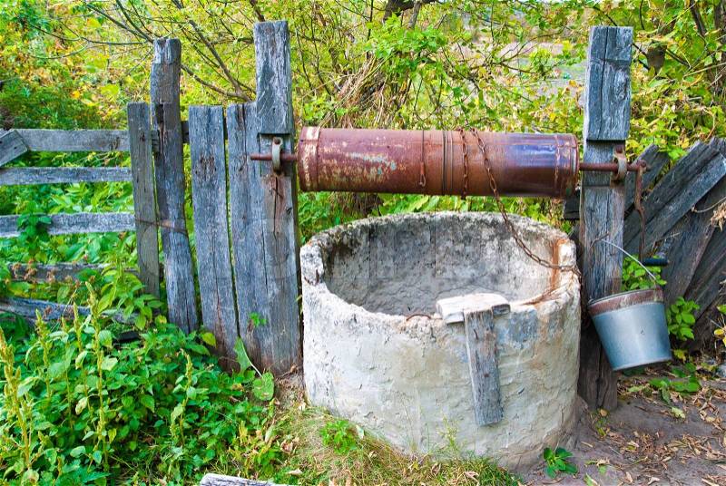 Old well in garden with fence, stock photo