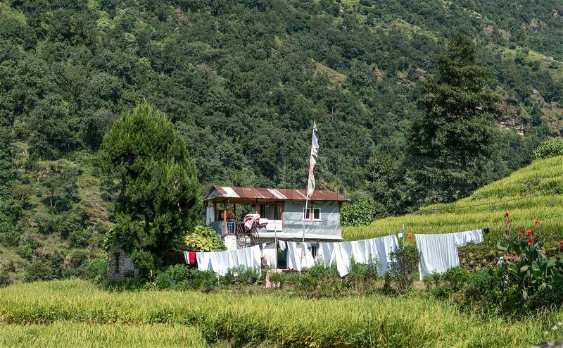 Houses in mountain village. Metal house on wooden pilares. Annapurna circuit, Nepal, stock photo