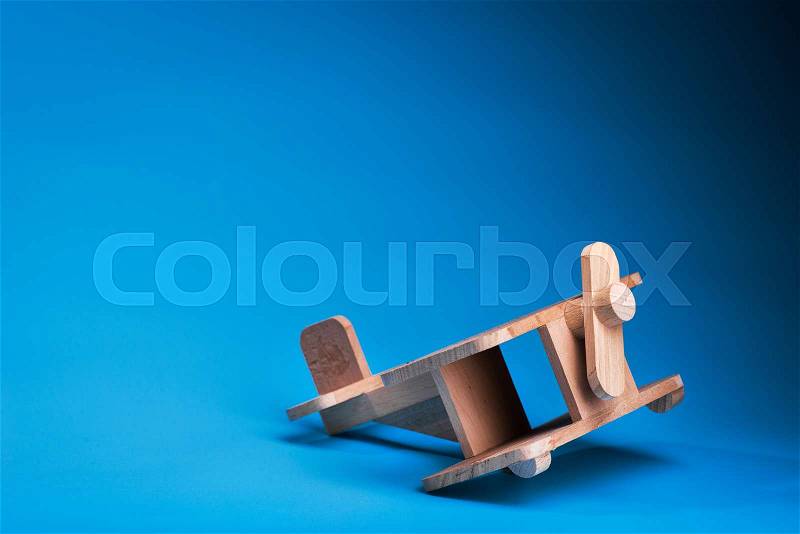 Wooden plane toy on blue background. vintage kids airplane, stock photo