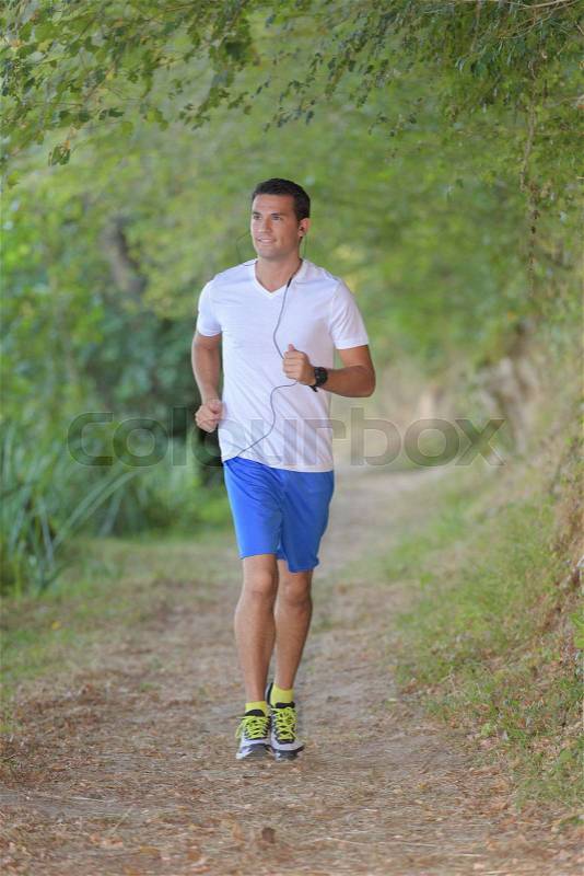 Man jogging wearing earphones, stock photo