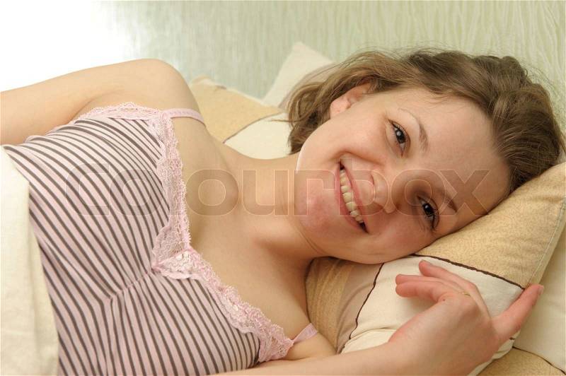 Smiling young girl after night sleep. Morning scene, stock photo