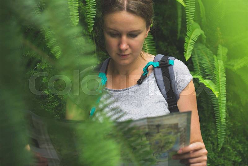 Woman traveller with map and backpack in the jungle, stock photo
