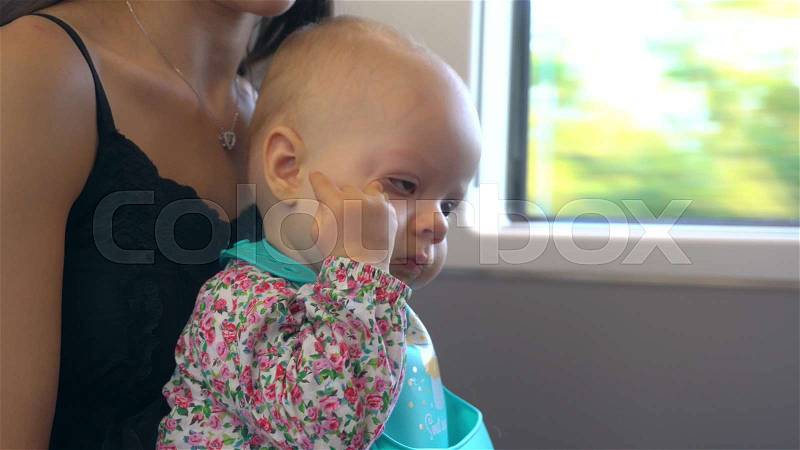 A sleepy baby refusing to eat on the train. Close-up shot, stock photo