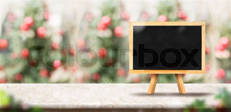 Blank blackboard menu on marble table top with abstract blur christmas tree red decor ball and snow fall background with bokeh light,Holiday backdrop,Mock up banner for display or montage of product, stock photo